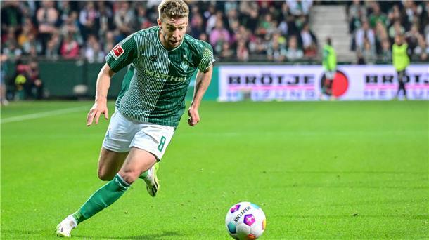 Ein Fußballer läuft über den Rasen. Es handelt sich um Mitchell Weiser vom SV Werder Bremen. 