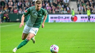 Ein Fußballer läuft über den Rasen. Es handelt sich um Mitchell Weiser vom SV Werder Bremen. 
