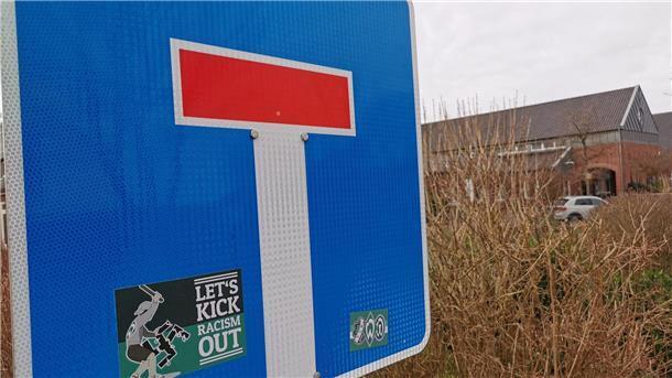 Sackgassenschild im Vordergrund, dahinter ein Gebäude