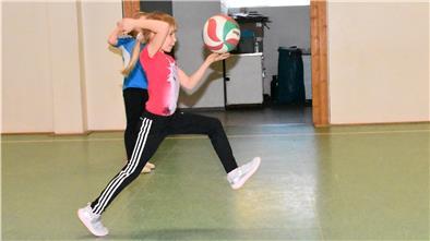 Ein Kind schlägt einen Prellball weg.