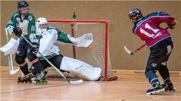 Inline-Skaterhockey-Spieler vor dem Tor.