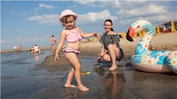 Zusätzlich zu den Urlaubern kommen auch Tagesgäste wie Ekaterina und ihre zwei Jahre alte Tochter Mija aus Bremen an die Küsten der Region.