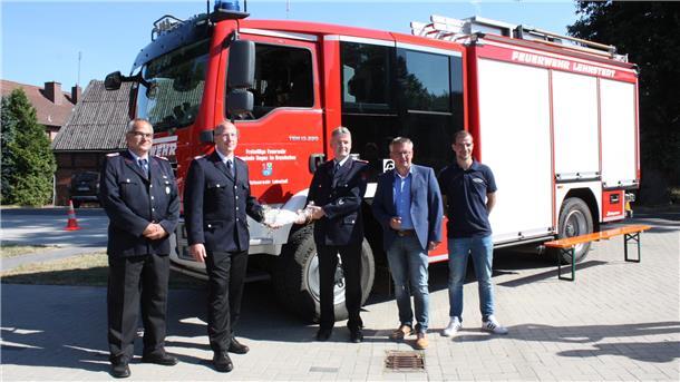 Zusammen mit Bürgermeister Andreas Wittenberg (Zweiter von rechts) und Feuerschutzausschuss-Vorsitzendem Christoph Werde (CDU) (rechts) überreicht Gemeindebrandmeister Marcus Sudmann (Mitte) den Schlüssel an Ortsbrandmeister Lars Gramatzki und seinen Stellvertreter Detlef Stolz (links) weiter. Foto: Kistner