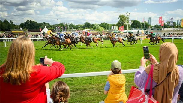 Außenseiter Palladium gewinnt 155. deutsches Galopp-Derby Zuschauende beobachten und fotografieren vom Rand der Bahn den Start der Pferde.