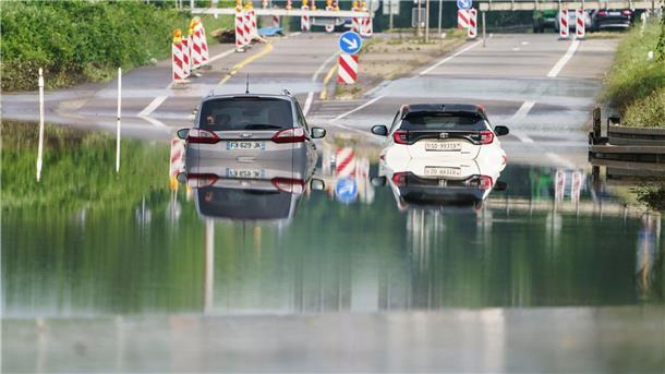 Zwei Autos stehen unter einer Saarbrücke in Saarbrücken im Hochwasser.