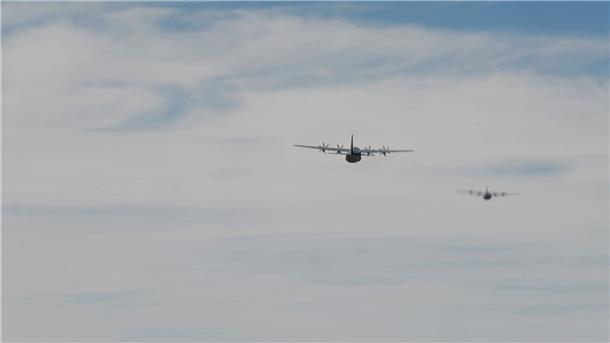 Zwei C-130J Super Hercules-Flugzeuge der US-Luftwaffe beim Abwurf von Paketen mit humanitärer Hilfe.