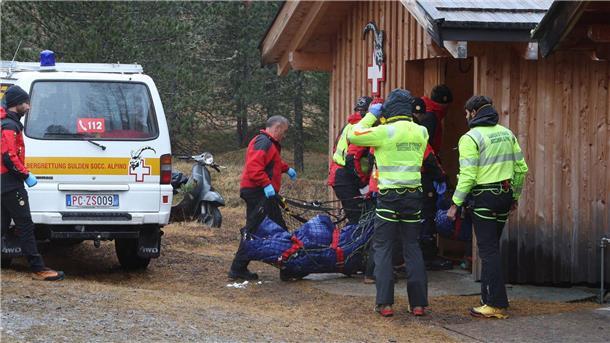 Zwei der Todesopfer werden zu einer Hütte getragen.