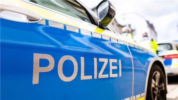 Zwei Einsatzfahrzeuge der Polizei stehen in Freiburg am Straßenrand.