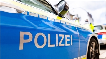 Zwei Einsatzfahrzeuge der Polizei stehen in Freiburg am Straßenrand.