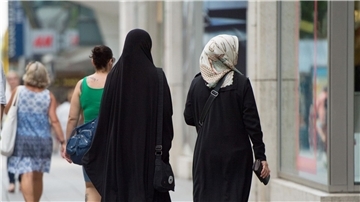 Zwei Frauen mit Kopftuch und langer Oberbekleidung.