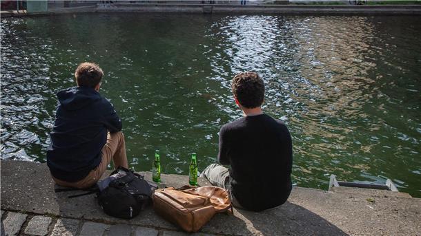 Zwei junge Männer am Ufer des Kanals Saint-Martin in Paris - mit jeweils einem Bier.