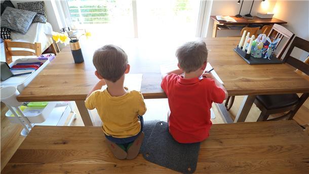 Zwei Jungen füllen zu Hause Lernbücher aus. Seit Beginn der Corona-Pandemie sitzen Geschwister – wie auf diesem Symbolbild – enger aufeinander als je zuvor.