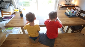Zwei Jungen füllen zu Hause Lernbücher aus. Seit Beginn der Corona-Pandemie sitzen Geschwister – wie auf diesem Symbolbild – enger aufeinander als je zuvor.