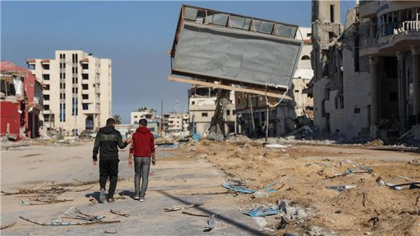 Feuerpause im Gaza-Krieg wird fortgesetzt Zwei Männer laufen durch Gaza-Stadt.