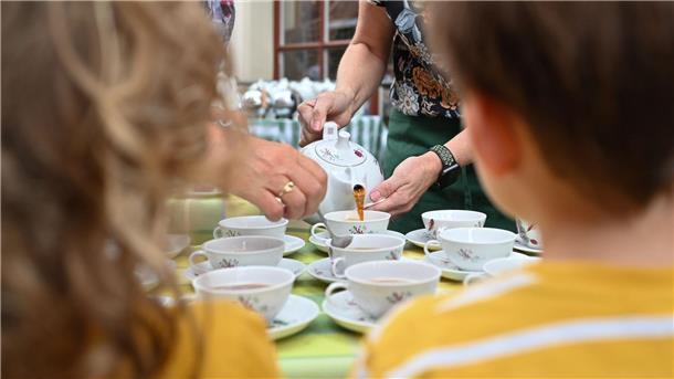 Rekord in Leer: 200 Tassen Ostfriesentee eingeschenkt Zwei Mitarbeiter des Teemuseums schenken unter den Augen zweier junger Gästen, Tee nach Ostfriesischer-Art ein.