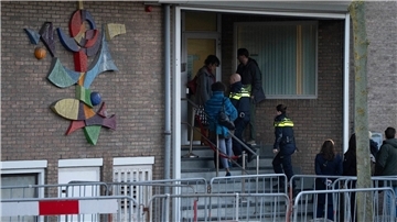 Zwei niederländische Polizeibeamte betreten das Hochsicherheitsgebäude des Gerichts.