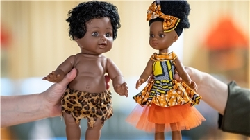 Zwei Puppen werden im Spielzeugmuseum Nürnberg gehalten. Die Puppe links im Bild hat schwarze Haut und trägt nichts als einen Lendenschurz mit Leopardenmuster. Sie habe aber die Gesichtszüge einer hellhäutigen Puppe, sagt eine Mitarbeiterin vom Spielzeugmuseum in Nürnberg. Die Puppe rechts hingegen wirke modern.