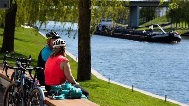 Zwei Radfahrer genießen am Sonntag bei schönem sommerlichen Wetter eine Pause am Mittellandkanal.
