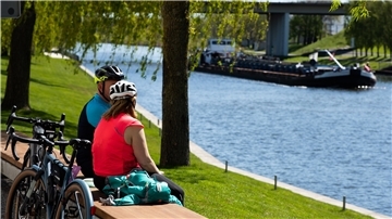 Zwei Radfahrer genießen am Sonntag bei schönem sommerlichen Wetter eine Pause am Mittellandkanal.