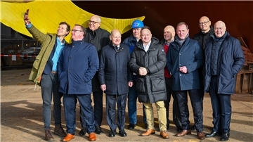 Zweigeteilt (v.l.): Falk Wagner (SPD Bremen), Bundestagsabgeordneter Uwe Schmidt und Bremens Regierungschef Andreas Bovenschulte lächeln fürs Selfie, während Kanzler Olaf Scholz mit den Gastgebern (v.l.) Betriebsrat Niels Bothen, Thorsten Rönner, Heinrich Rönner, Friedrich Norden, Heiner Rönner, Kurt Zech posiert.