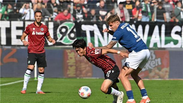 Zweikampf um den Ball: Hayate Matsuda (Hannover 96) wird von Joel Grodowski (Arminia Bielefeld) bedrängt.